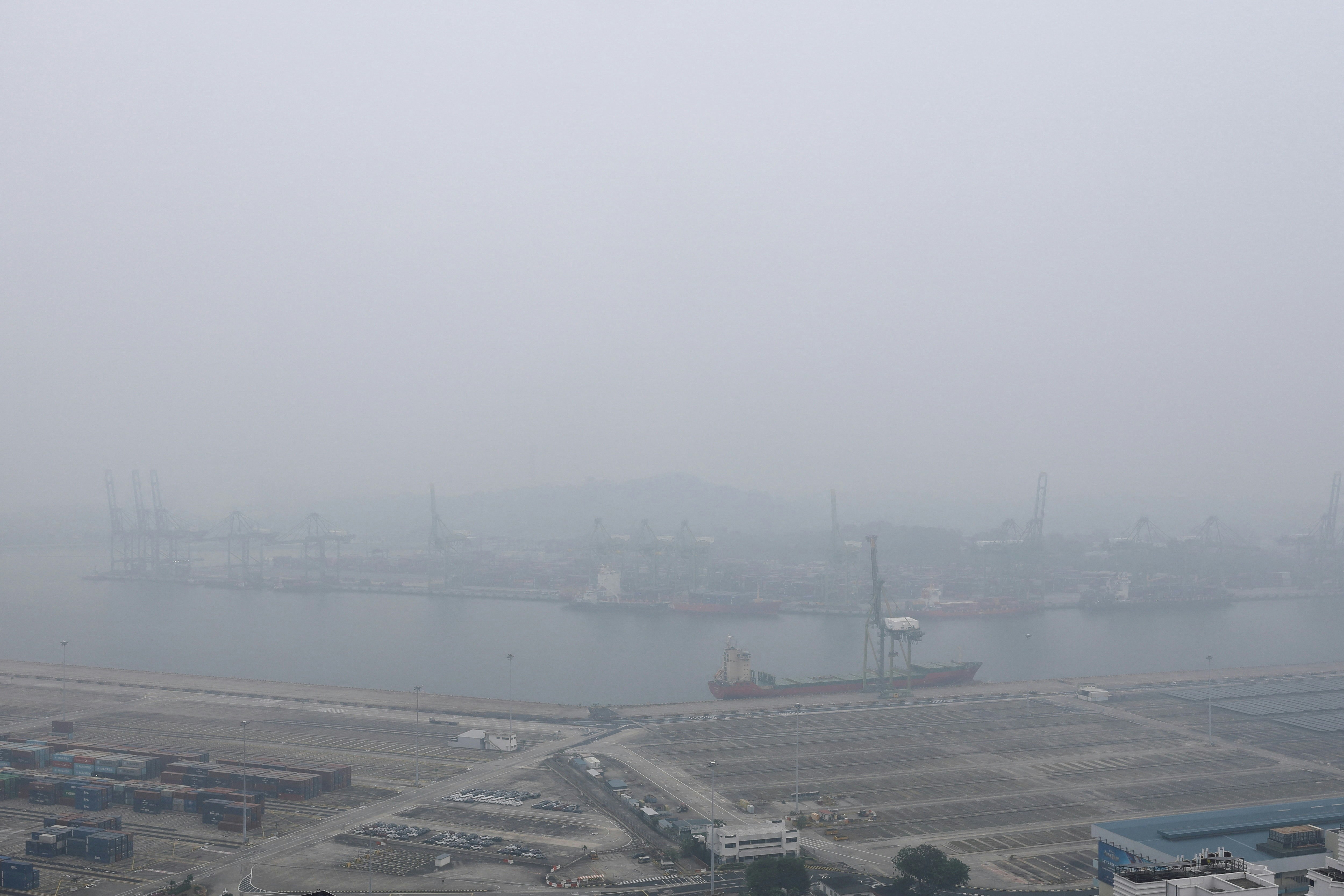 2026年10月14日,新加坡丹戎巴葛旧港码头笼罩在烟雾之中,区域森林火灾产生的浓烟导致整个岛屿城市国家的能见度降低。(Reuters)