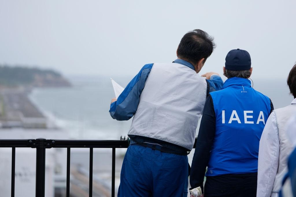 2023年7月5日,日本福岛,图为国际原子能机构(IAEA)人员在参观福岛核电站时,聆听东京电力公司人员介绍核污水处理设施。(Getty)
