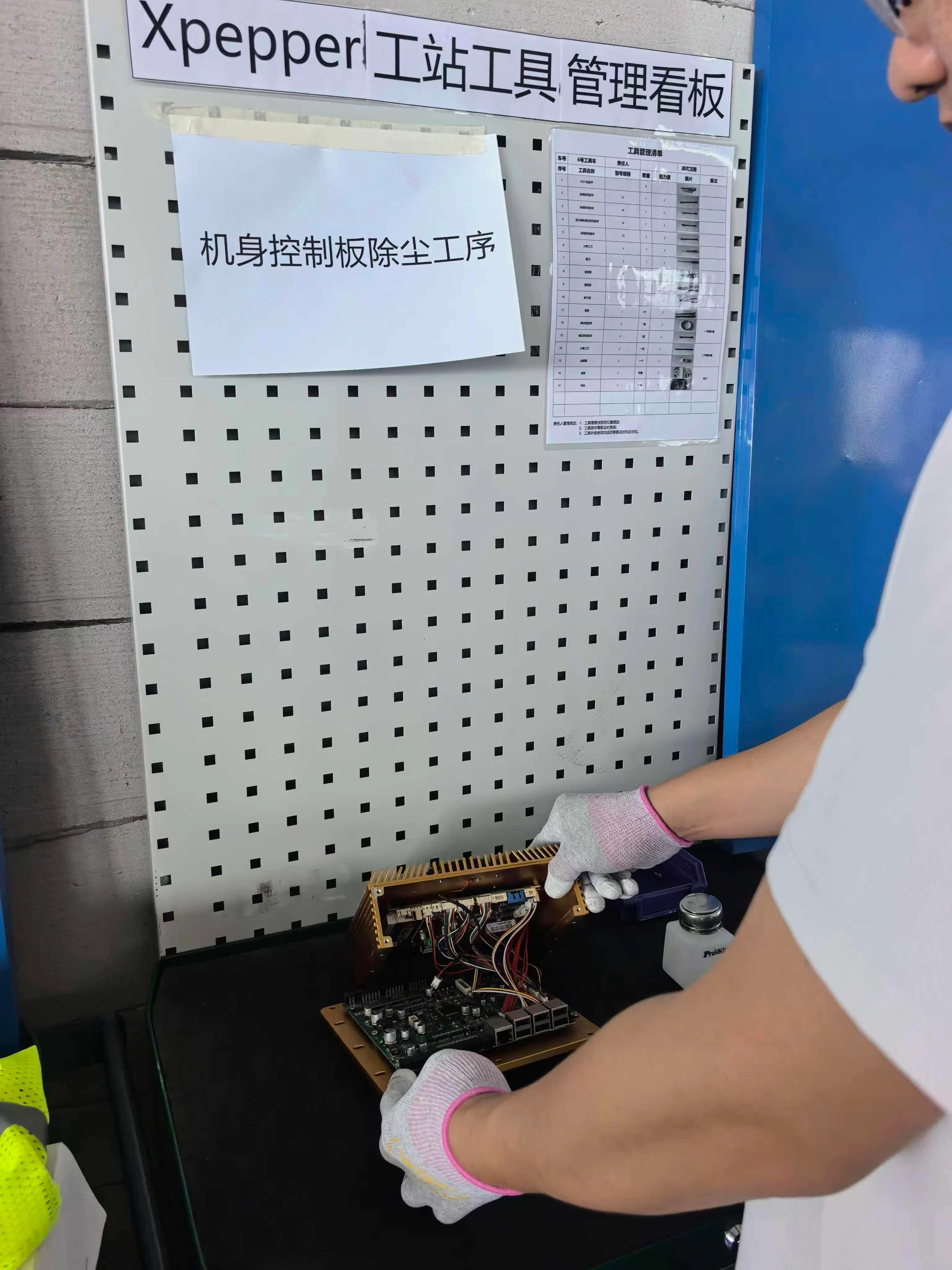 数据采集员头戴摄像头完成机身控制板除尘,记录下双手操作过程,让机器人从真实作业中“学习”这一工序。(受访者提供)