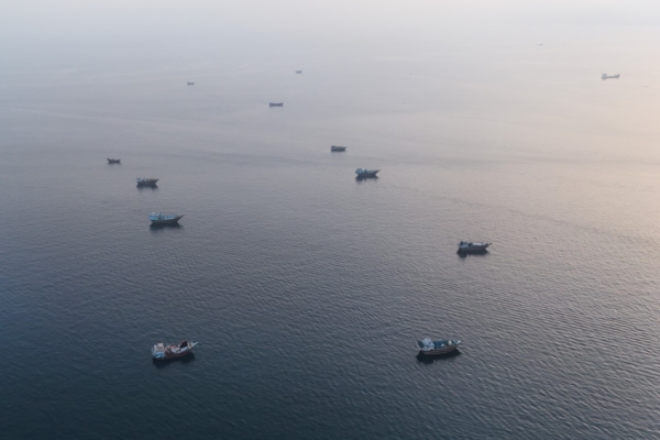 2026年6月27日,在靠近霍爾木茲海峽(Strait of Hormuz)的阿曼北部穆桑代姆半島(Musandam Peninsula)附近,船隻錨泊在海面上。(AFP)