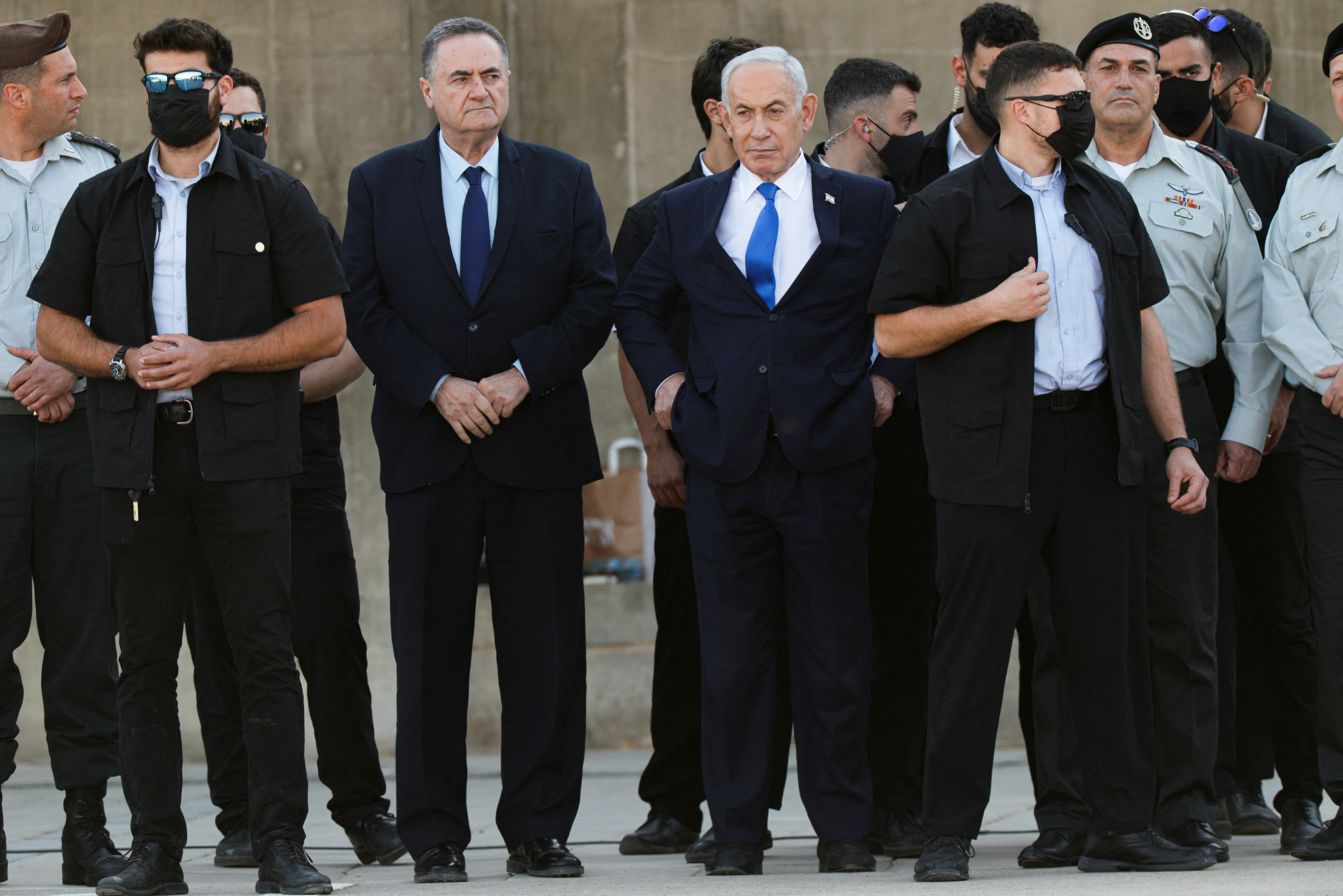 2026年10月21日,以色列总理内塔尼亚胡(Benjamin Netanyahhu,中)、国防部长卡茨(Israel Katz,左)以及以色列军队总参谋长扎米尔(Eyal Zamir,右),在以色列米茨佩拉蒙(Mitzpe Ramon)附近的一处基地出席了以色列军队新任军官的毕业典礼。(Reuters)