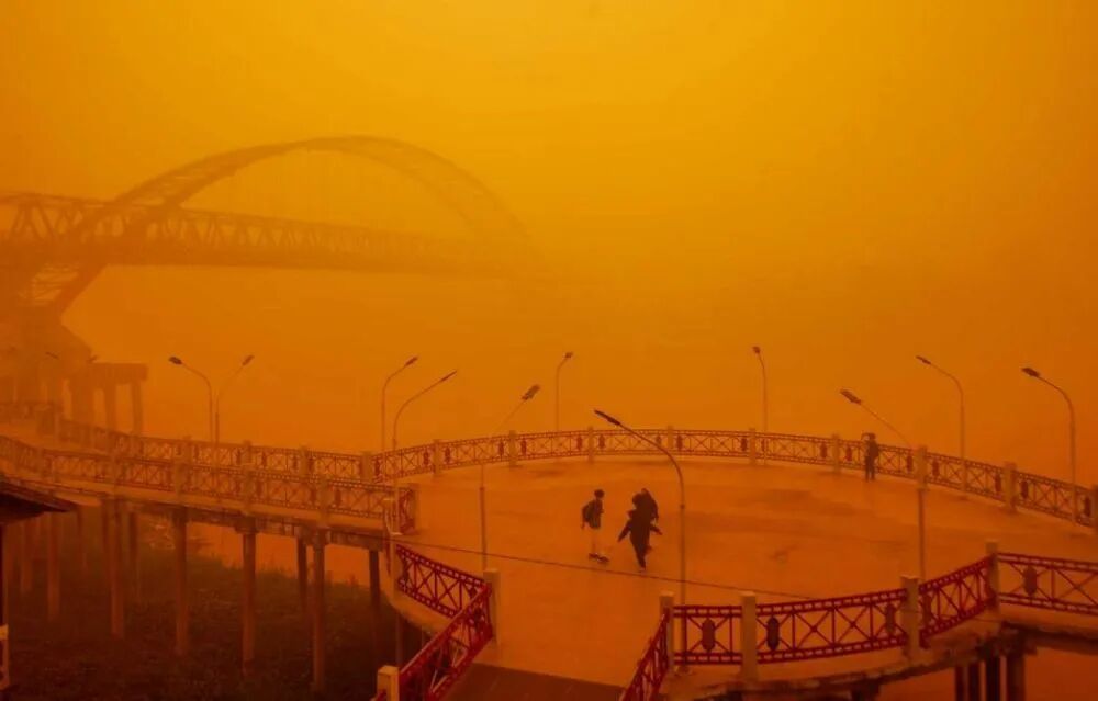 10月14日,印尼中加里曼丹省帕朗卡拉亚市卡哈扬河畔,人们穿行在红褐色的烟霾中。(图源:路透社)