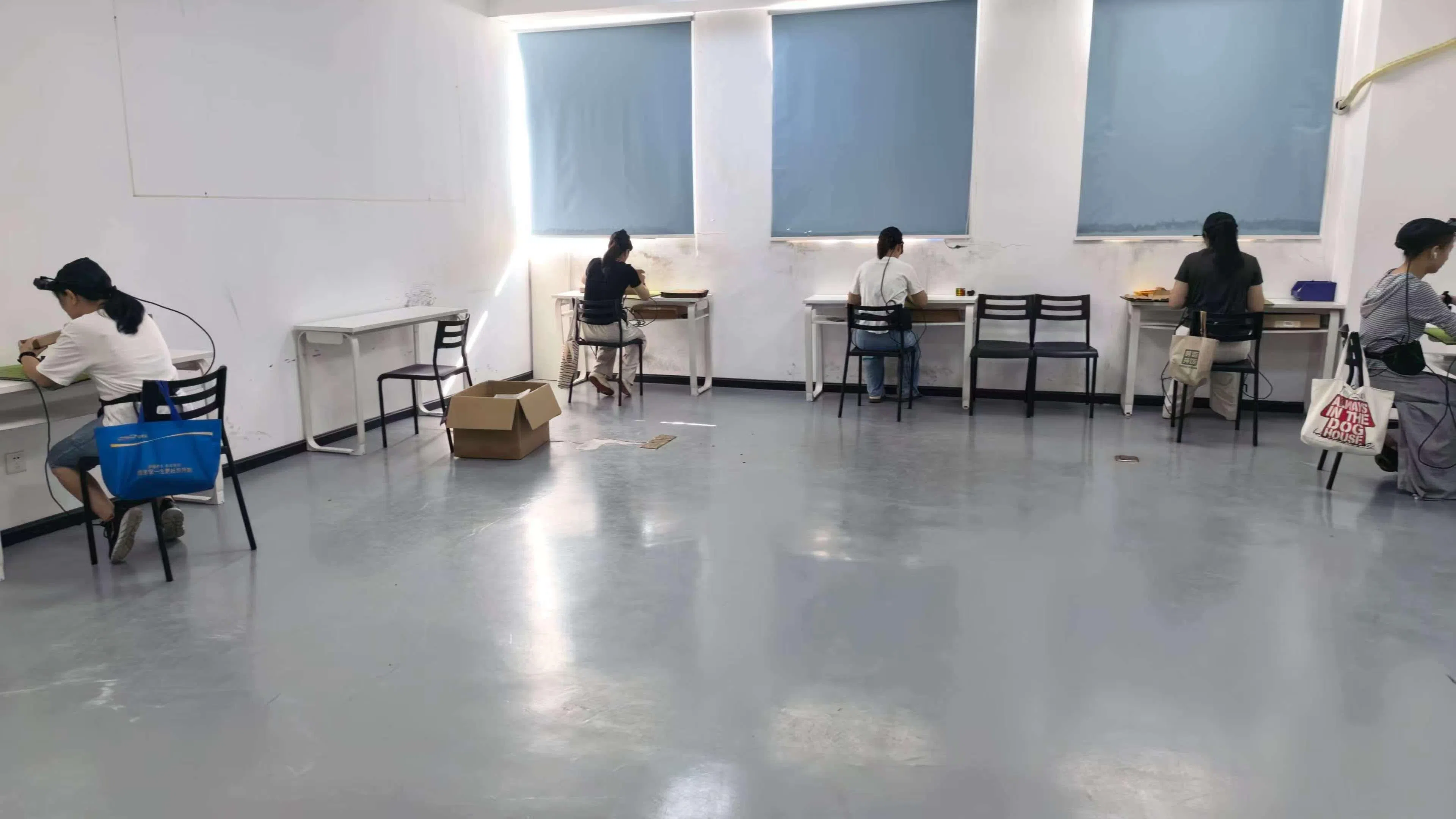 数采员坐在工位前,反复进行桌面物品拿取、整理等操作,用头戴设备记录手部动作。(受访者提供)