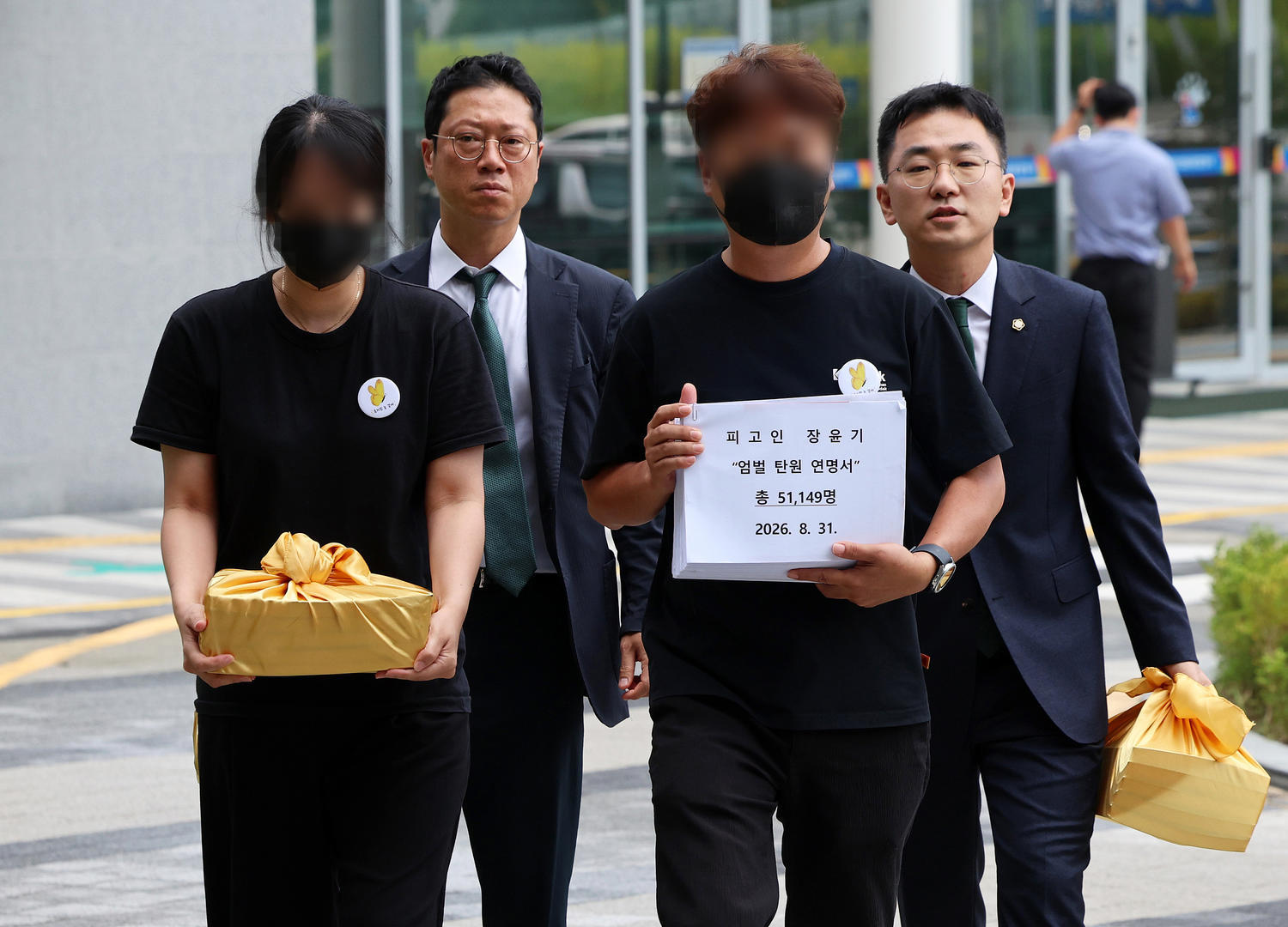 ▲当地时间2026年8月31日，韩国光州，“女高中生杀害案”凶手张允基一审第四次公审当天，遇害者李采元的父母与律师手持严惩请愿书前往光州地方法院信访室（图据视觉中国）