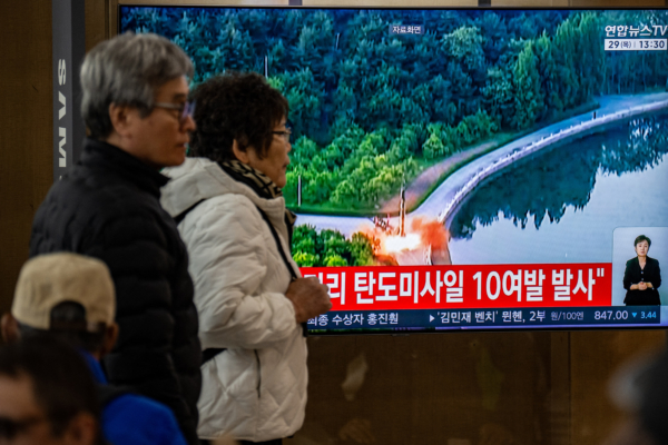 2026年10月29日,韓國首爾站民眾經過一面正在播放朝鮮導彈發射資料畫面的新聞螢幕。當天,朝鮮向東部海域(日本海)發射約12枚短程彈道導彈,韓朝邊境緊張局勢持續升高。 (Philip Fong/AFP via Getty Images)