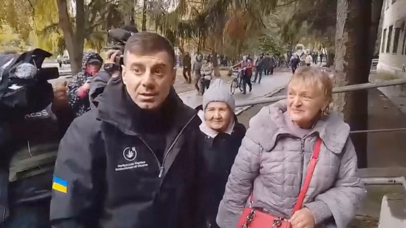 乌克兰议会人权事务专员德米特罗·卢比涅茨在乌克兰赫尔松州奥列什基市迎接前往乌克兰控制区的居民。(2026年10月30日)