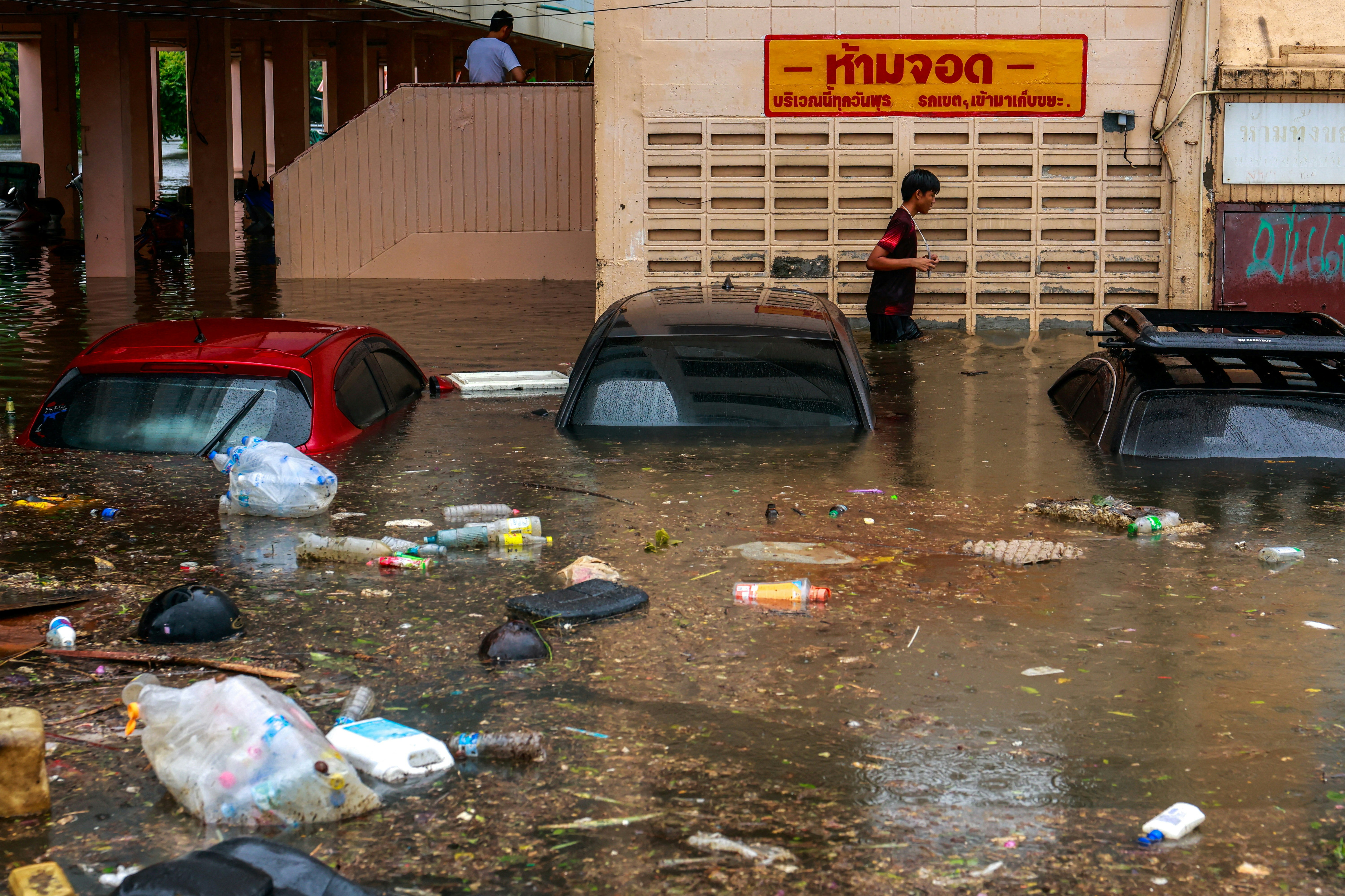 2026年9月26日,泰国曼谷,一名行人趟过暴雨中被洪水淹没的街道。(Reuters)