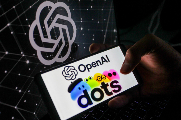 2026年10月6日,一部顯示OpenAI標誌和彩色「圓點」(dots)的智能手機擺放在OpenAI標誌前。(Imen Ben Youssef/Hans Lucas/AFP via Getty Images)