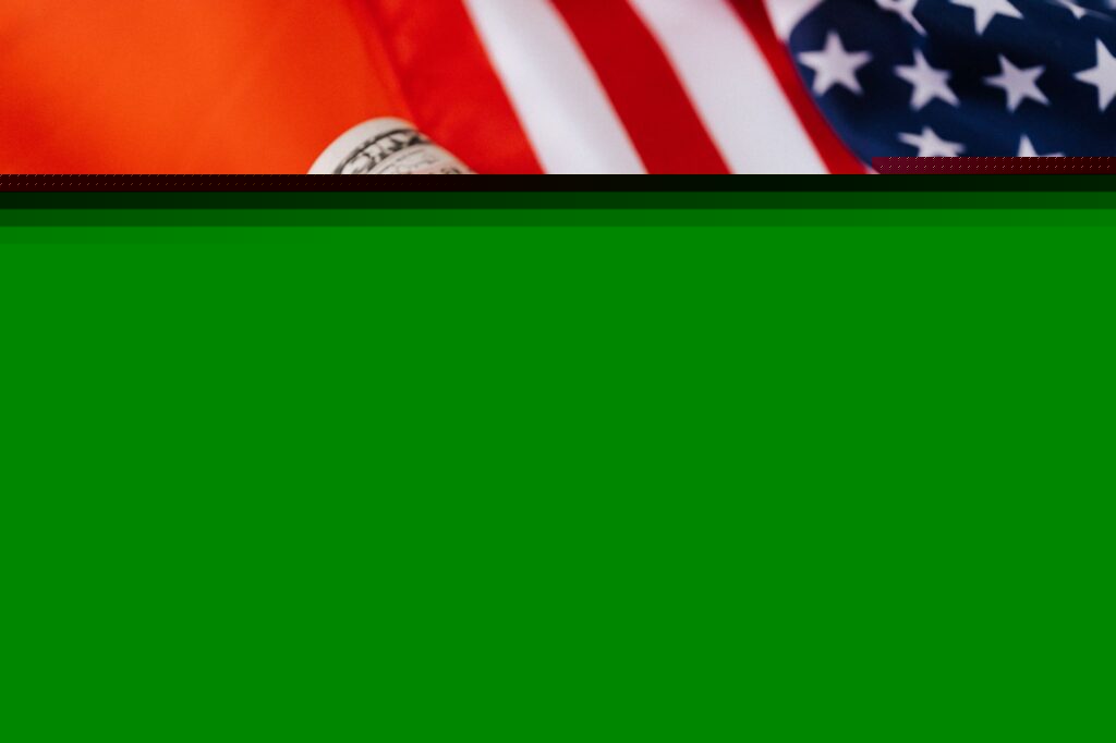 From above of roll of dollar bills tied with rubber band on bright American flag with stars and stripes symbolizing unity and peace