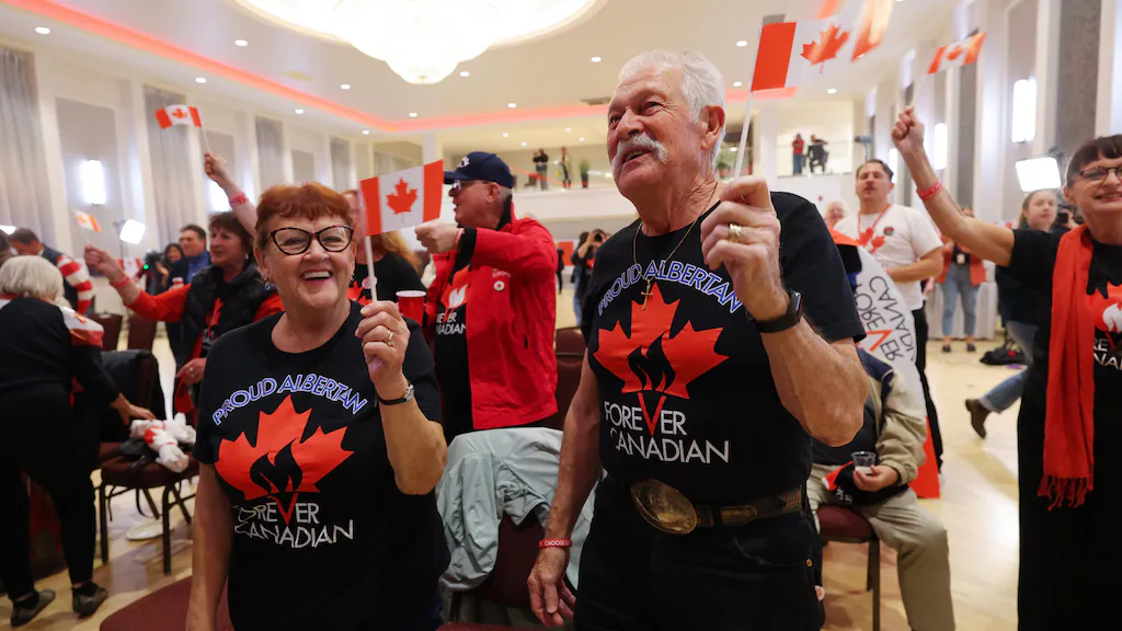 Rassemblement de gens qui brandissent des drapeaux du Canada.