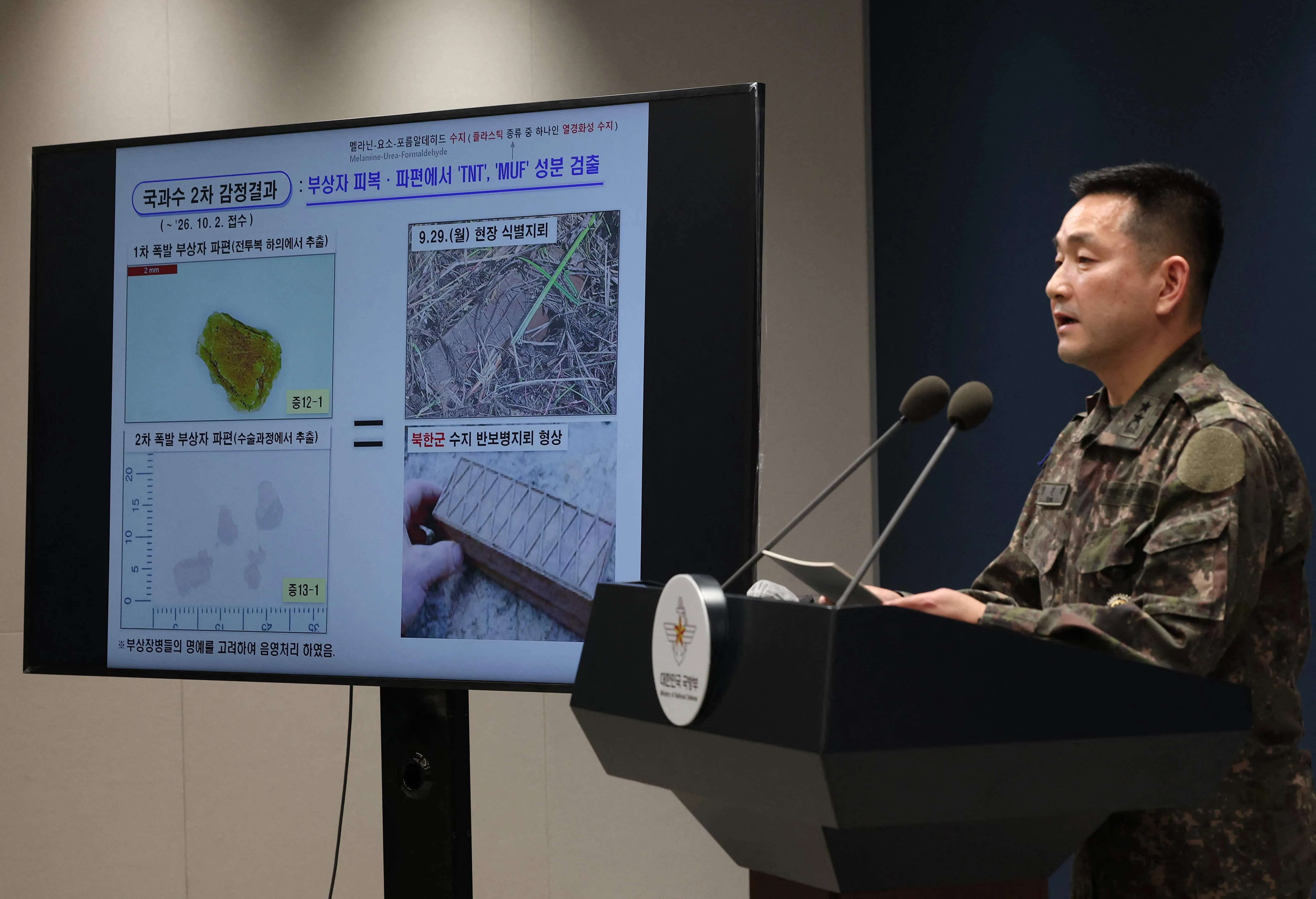 韩国联合参谋本部作战部长杨镇赫向记者介绍在韩朝非军事区地雷爆炸现场发现的地雷碎片。调查确认它们来自朝鲜自1969年起使用的地雷型号。(法新社)