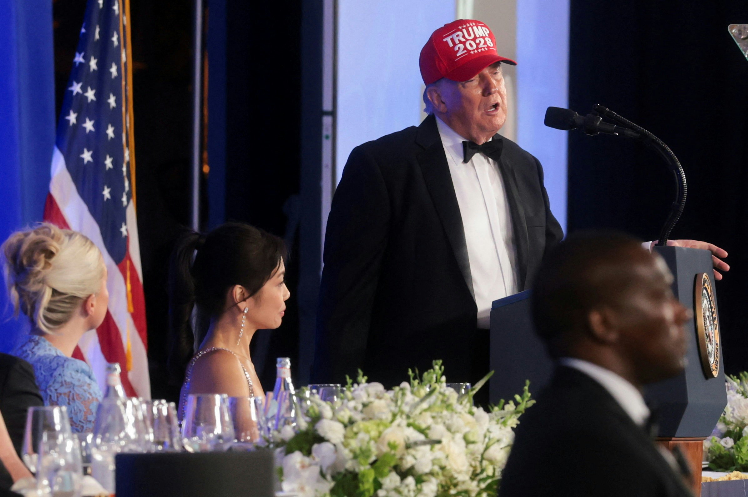 2026年7月24日,美国总统特朗普(Donald Trump,又译川普)在白宫记者协会晚宴上发表讲话,头戴一顶写有「特朗普2028」的帽子。(Reuters)