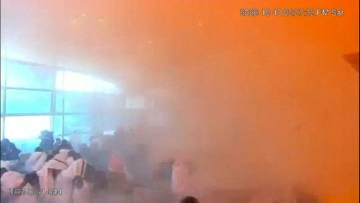 在这张来自发布影片的截图中,闭路电视片段显示了2026年10月10日沙特阿拉伯利雅得哈立德国王国际机场遇袭瞬间,民众在烟雾中的反应。(Reuters)