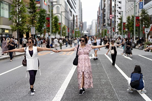 圖為2023年10月1日,日本東京銀座區,中國遊客正在擺姿勢拍照。(Tomohiro Ohsumi/Getty Images)