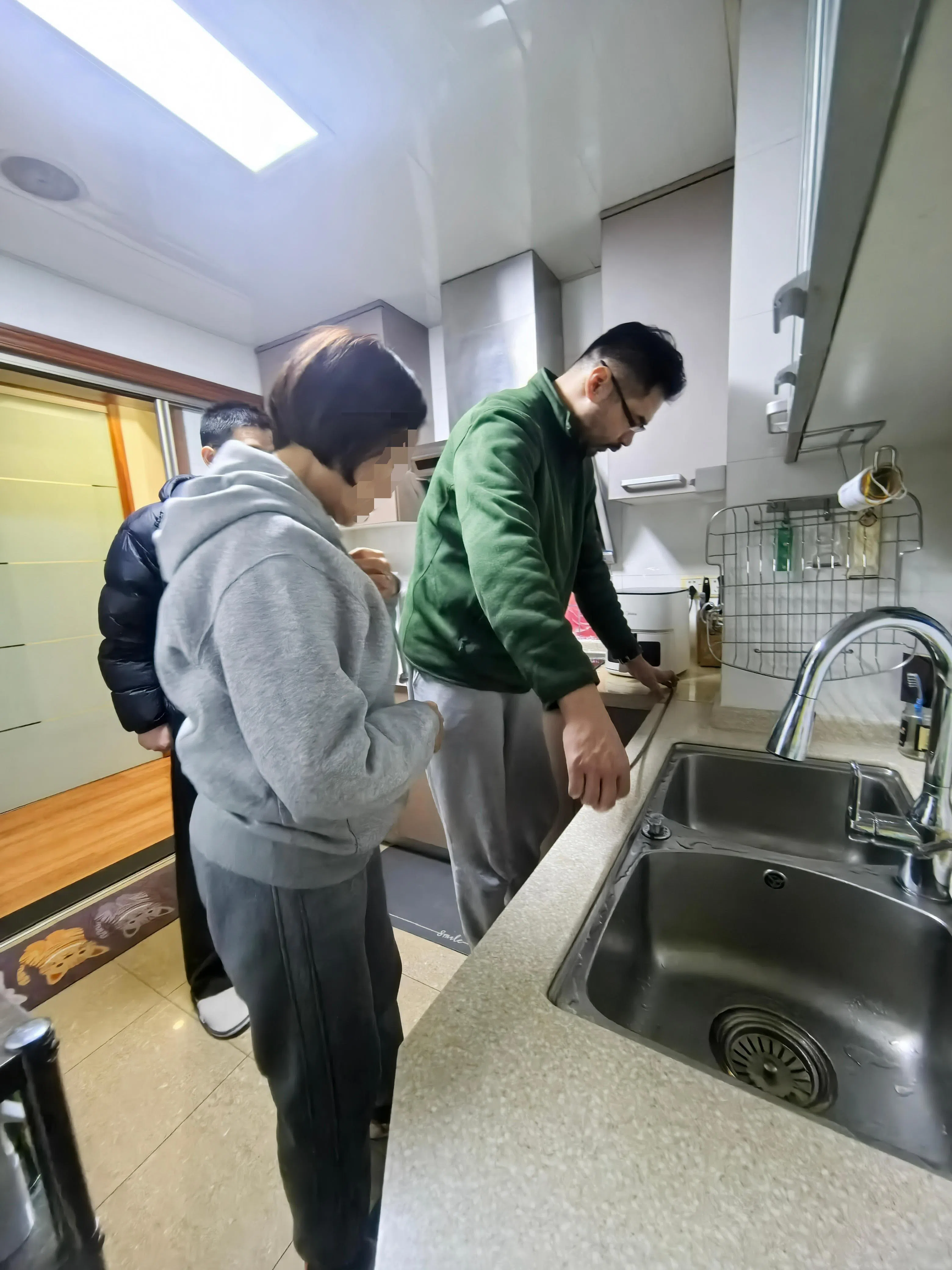 适老化改造设计师王晨(右)在客户家测量厨房操作台尺寸。(受访者提供)